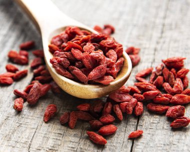 Sağlıklı beslenmek için kuru kırmızı goji üzümleri eski ahşap arka planda.