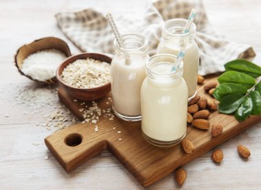 Beton arka planda cam şişelerde alternatif vejetaryen süt türleri. Üst görünüm