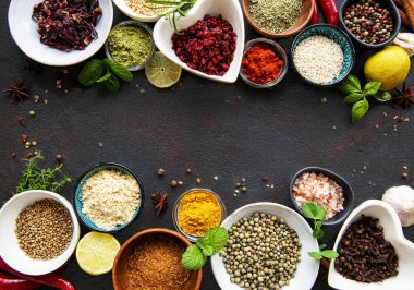 Siyah beton arka planda bir kasede çeşitli baharatlar. Üst görünüm kopyalama alanı.