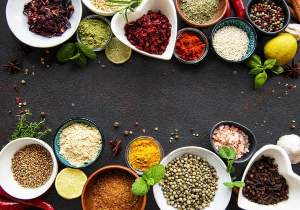 Siyah beton arka planda bir kasede çeşitli baharatlar. Üst görünüm kopyalama alanı.