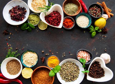 Siyah beton arka planda bir kasede çeşitli baharatlar. Üst görünüm kopyalama alanı.