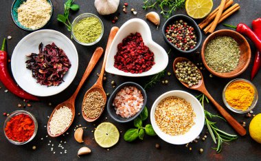 Siyah beton arka planda bir kasede çeşitli baharatlar. Üst görünüm kopyalama alanı.