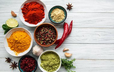 Beyaz ahşap arka planda çeşitli baharatlar, üst görünüm