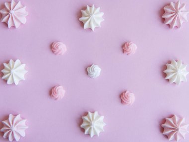 Merengue arka planı. Düz yatıyordu. Üst Manzara. Pembe arka planda ev yapımı tatlı merengue.