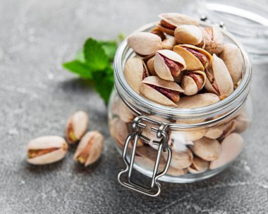 Fıstıklı kavanoz ve gri beton arka plan.