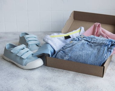 Açık bir karton kutuda çocuklar için kıyafetler. İnternetten alışveriş konsepti. Elbise teslimatı..