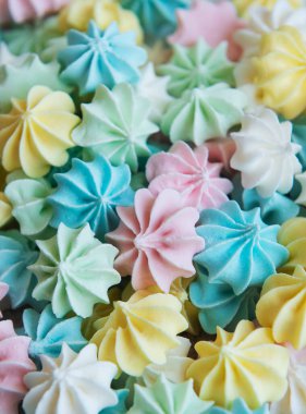 Yakın plan lezzetli kurabiyeler pastel renkli arka plan. Fransız hamur işleri, tatlı kıvrımlı şekerler.