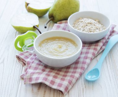 Bebek mamaları ve armutlarla dolu bir kase.