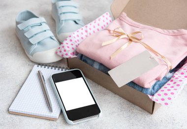 Açık bir karton kutuda çocuklar için kıyafetler. İnternetten alışveriş konsepti. Elbise teslimatı..