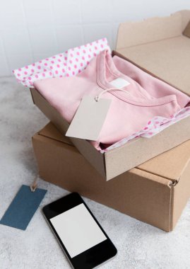 Açık bir karton kutuda çocuklar için kıyafetler. İnternetten alışveriş konsepti. Elbise teslimatı..