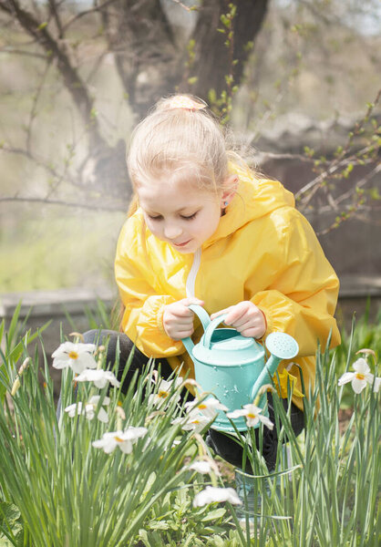Маленькая девочка в саду с зеленой кастрюлей