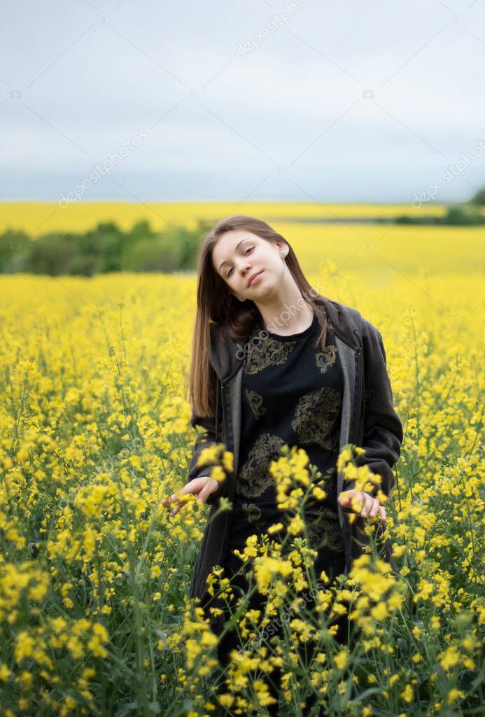 Young caucasian  girl on yellow rapeseed field