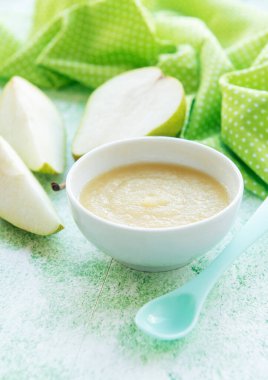 Bebek mamaları ve armutlarla dolu bir kase.