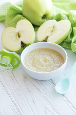 Bebek maması ve elmalarla dolu bir kase.