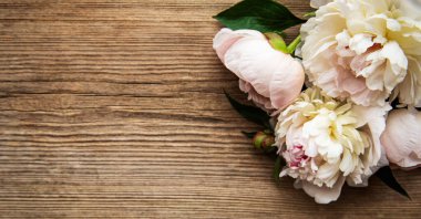 Pembe şakayık çiçekleri eski ahşap arka planda bir sınır olarak