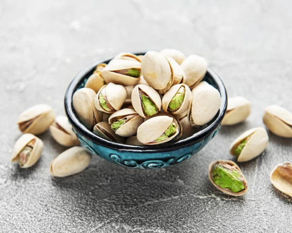 Gri beton arka planda fıstıklı kase