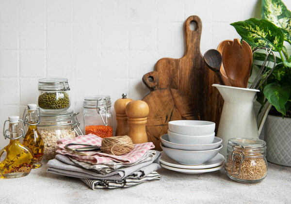 Kitchen utensils, tools and dishware on on the background white tile wall. Interior, modern kitchen space in bright colors. Blank space for a text, front view