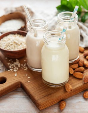 Beton arka planda cam şişelerde alternatif vejetaryen süt türleri. Üst görünüm