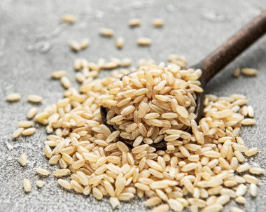 Gri beton arka planda çiğ kahverengi pirinç