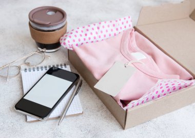 Açık bir karton kutuda çocuklar için kıyafetler. İnternetten alışveriş konsepti. Elbise teslimatı..