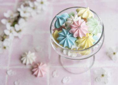 Pembe kaplamalı camda küçük renkli kremalar var.