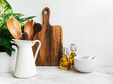 Arka plandaki beyaz fayans duvarında mutfak gereçleri, aletler ve bulaşık malzemeleri var. İç mekan, parlak renklerde modern mutfak alanı. Metin için boşluk, ön görünüm