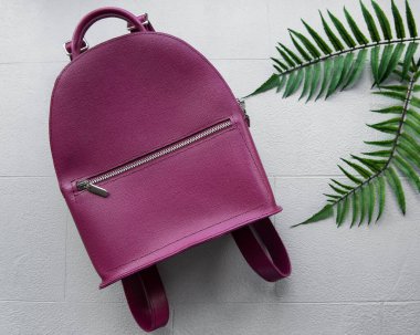 Gri fayans üzerinde Burgundy kadın sırt çantası, üst manzara. Şık aksesuar