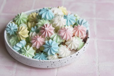 Seramik kasede pembe fayanslar üzerinde küçük renkli kremalar.