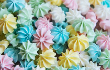 Yakın plan lezzetli kurabiyeler pastel renkli arka plan. Fransız hamur işleri, tatlı kıvrımlı şekerler.