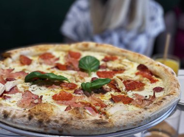 Pizza soslu pizza, mozzarella peyniri ve pepperoni. Restoranda masada pizza.