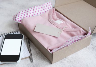 Açık bir karton kutuda çocuklar için kıyafetler. İnternetten alışveriş konsepti. Elbise teslimatı..