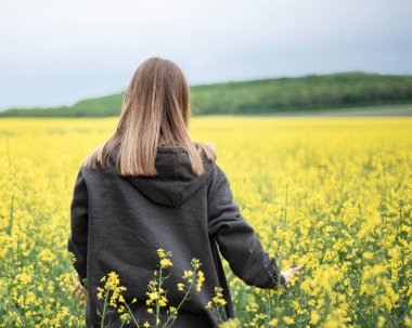 Sarı kolza tohumu tarlasında beyaz bir kız.