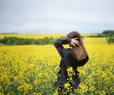 Sarı kolza tohumu tarlasında beyaz bir kız.