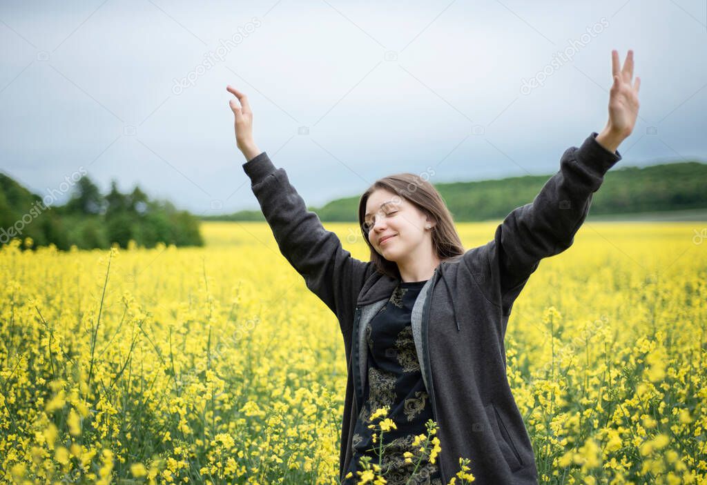 Young caucasian  girl on yellow rapeseed field