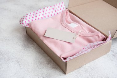 Açık bir karton kutuda çocuklar için kıyafetler. İnternetten alışveriş konsepti. Elbise teslimatı..