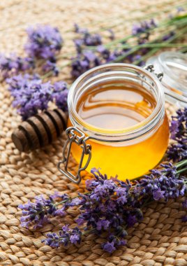 Ballı kavanoz ve hasır üzerinde taze lavanta çiçekleri. 