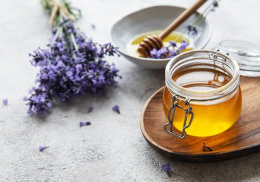 Ballı kavanozlar ve çimentoda taze lavanta çiçekleri.