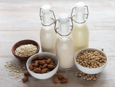 Farklı bitki sütlü şişeler - soya, badem ve yulaf sütü.