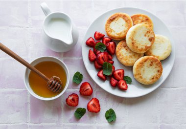 Süzme peynirli krep, seramik tabakta taze çilekli ricotta böreği. Sağlıklı ve lezzetli sabah kahvaltısı.  