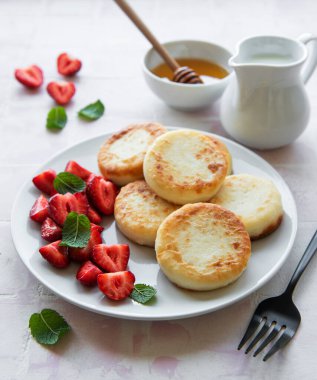 Süzme peynirli krep, seramik tabakta taze çilekli ricotta böreği. Sağlıklı ve lezzetli sabah kahvaltısı.  