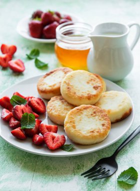 Süzme peynirli krep, seramik tabakta taze çilekli ricotta böreği. Sağlıklı ve lezzetli sabah kahvaltısı.  