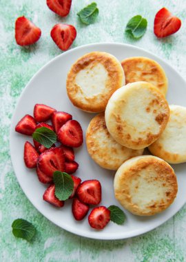 Süzme peynirli krep, seramik tabakta taze çilekli ricotta böreği. Sağlıklı ve lezzetli sabah kahvaltısı.  