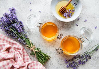 Ballı kavanozlar ve çimentoda taze lavanta çiçekleri.