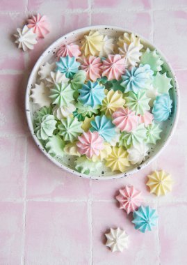 Seramik kasede pembe fayanslar üzerinde küçük renkli kremalar.