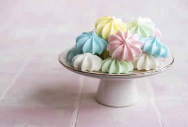 Seramik tezgahta seramik arka planda küçük renkli kremalar