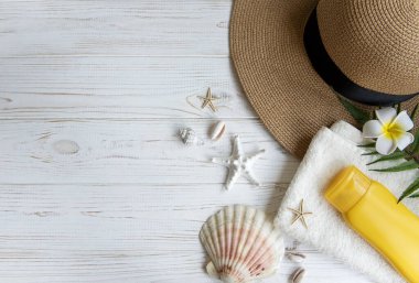 Yaz tatili kavramı. Hasır şapka ve deniz kabuklu plaj aksesuarları ve beyaz ahşap arka planda deniz yıldızı.