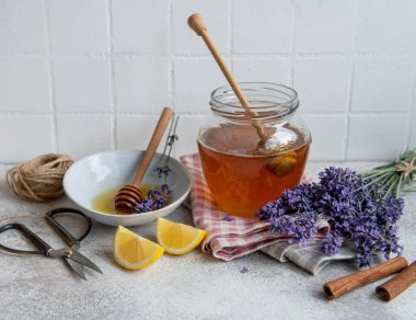 Ballı kavanoz ve çimento kaplı taze lavanta çiçekleri.