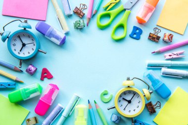Mavi arkaplanda farklı kırtasiye malzemesi çerçevesi, metin için boş alanı olan düz bir yer. Okula geri dön.