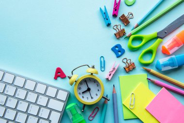 Mavi arkaplanda farklı kırtasiye malzemesi çerçevesi, metin için boş alanı olan düz bir yer. Okula geri dön.