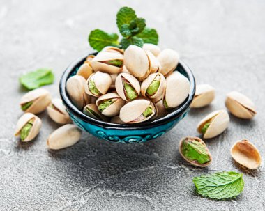 Gri beton arka planda fıstıklı kase